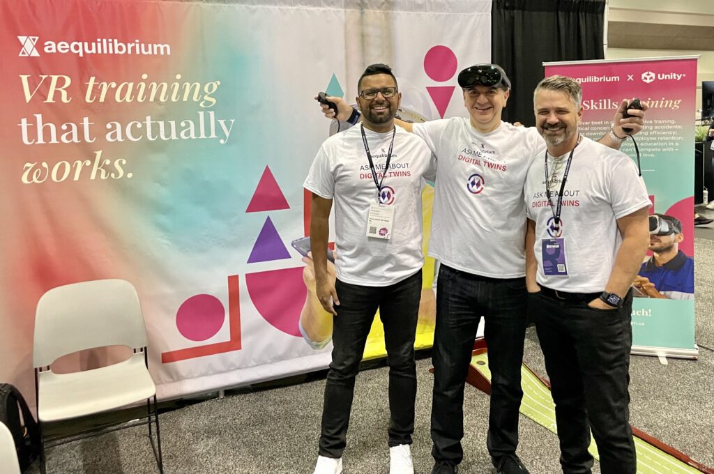 The AEQ team at AWE 2023, posing in front of their booth and sporting the wearable VR demos.